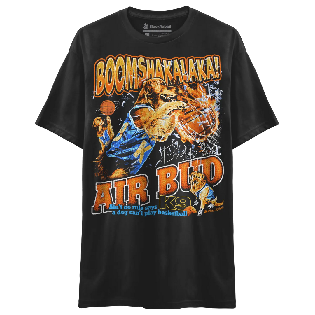 A black t-shirt featuring a graphic of a golden retriever playing basketball with the text ’BOOMSHAKALAKA!’ and ’AIR BUD K9’’.