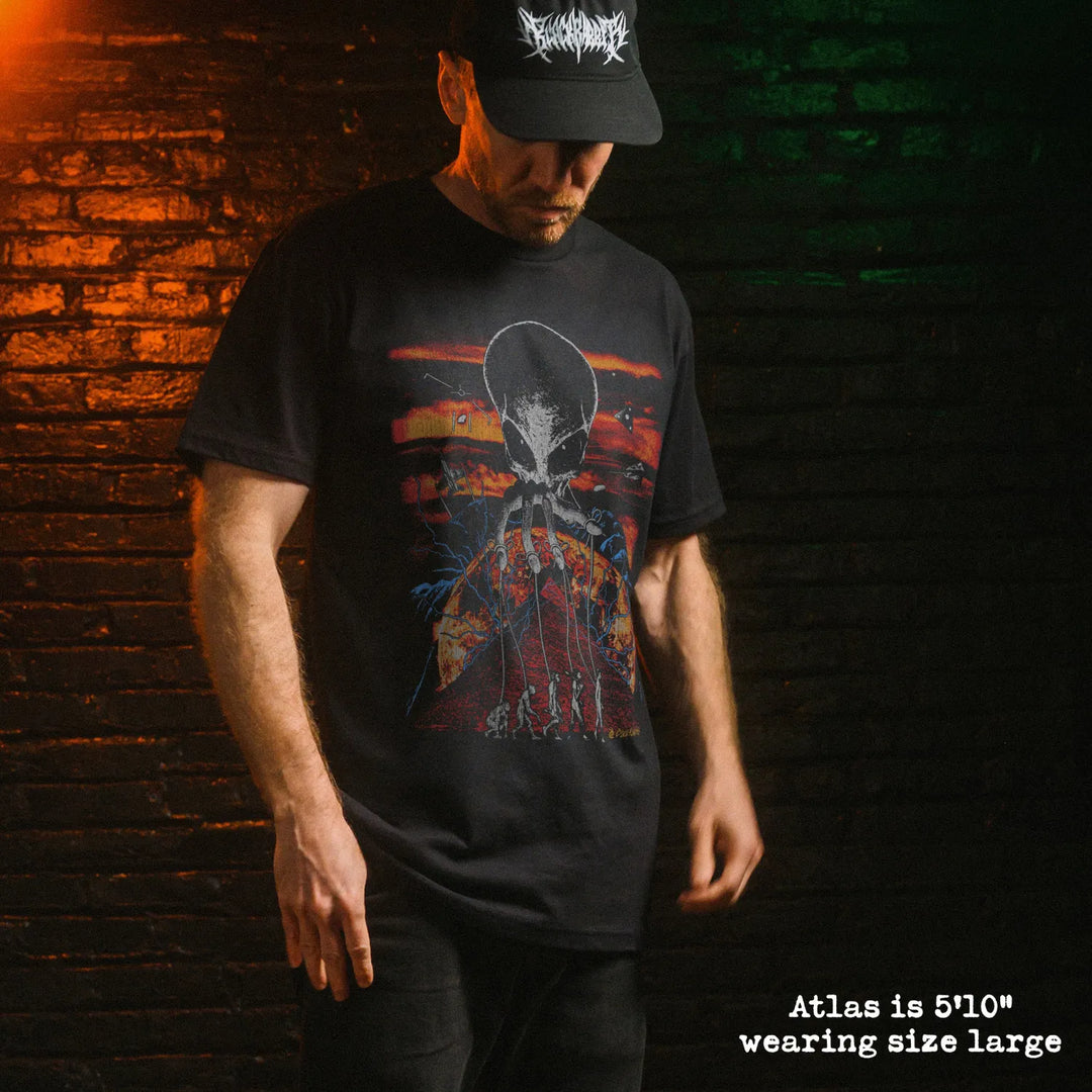 Male model wearing black premium tee with alien overlord graphic 