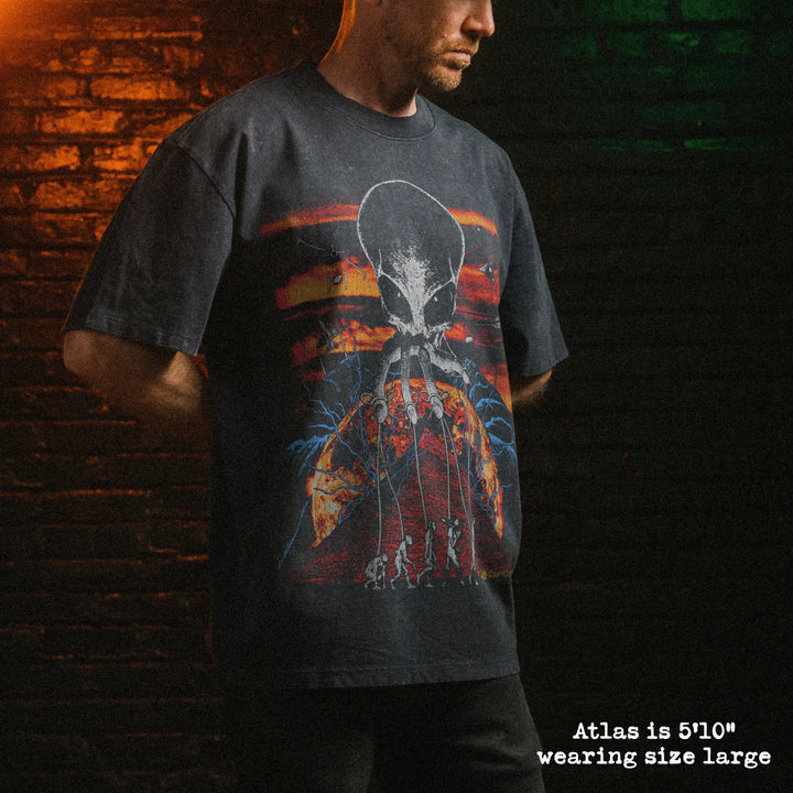 Male model wearing stone washed heavy tee with alien overlord graphic 