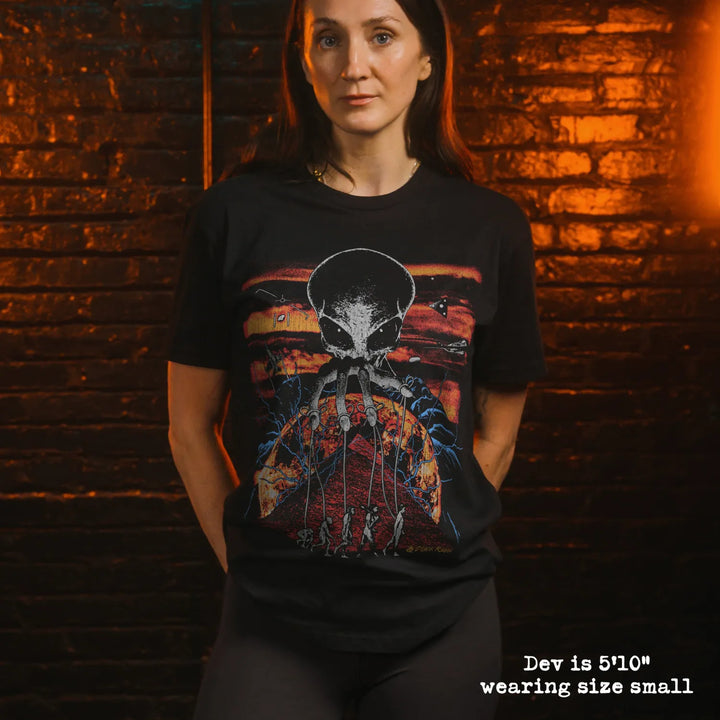Model wearing black premium tee with alien overlord graphic 