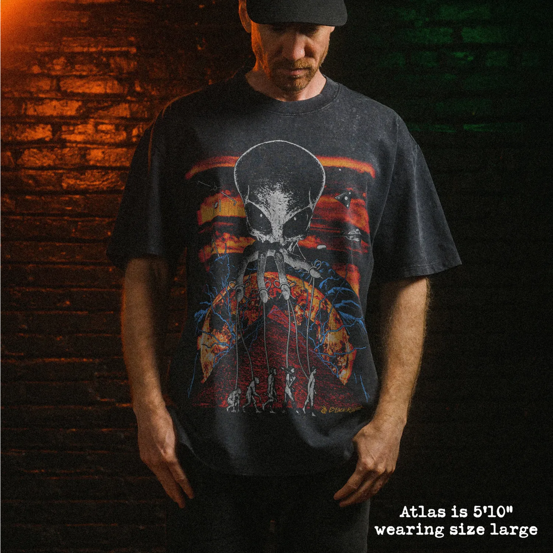 Male model wearing stone washed heavy tee with alien overlord graphic 