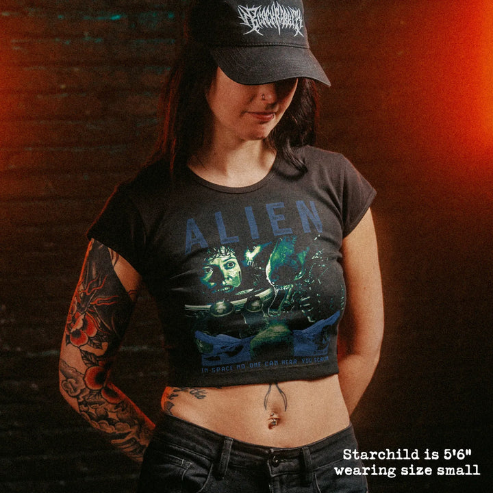 Female model wearing cropped baby tee with Alien graphic
