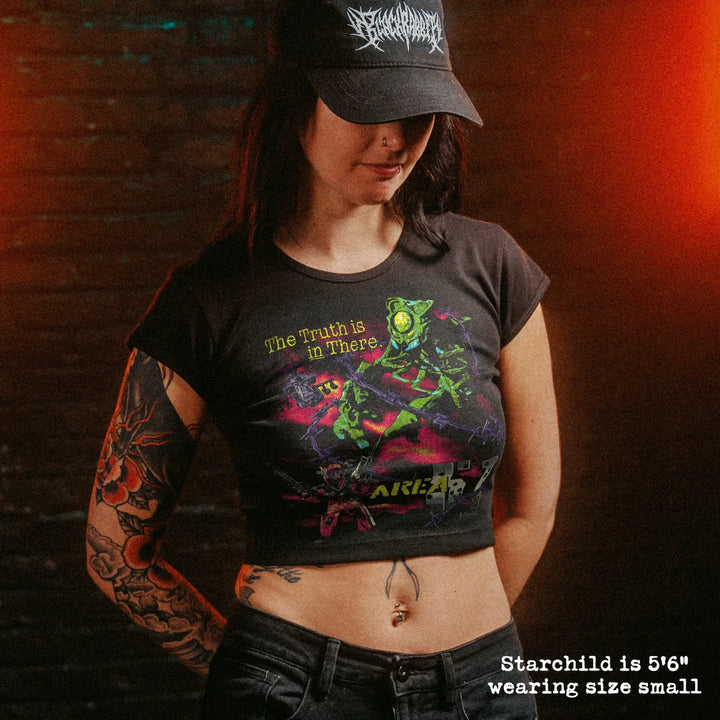 Female model wearing cropped baby tee with area 51 graphic
