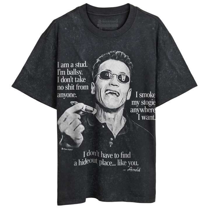 A dark grey t-shirt featuring a black and white image of Arnold Schwarzenegger wearing sunglasses and holding a cigar, with various quotes attributed to him.