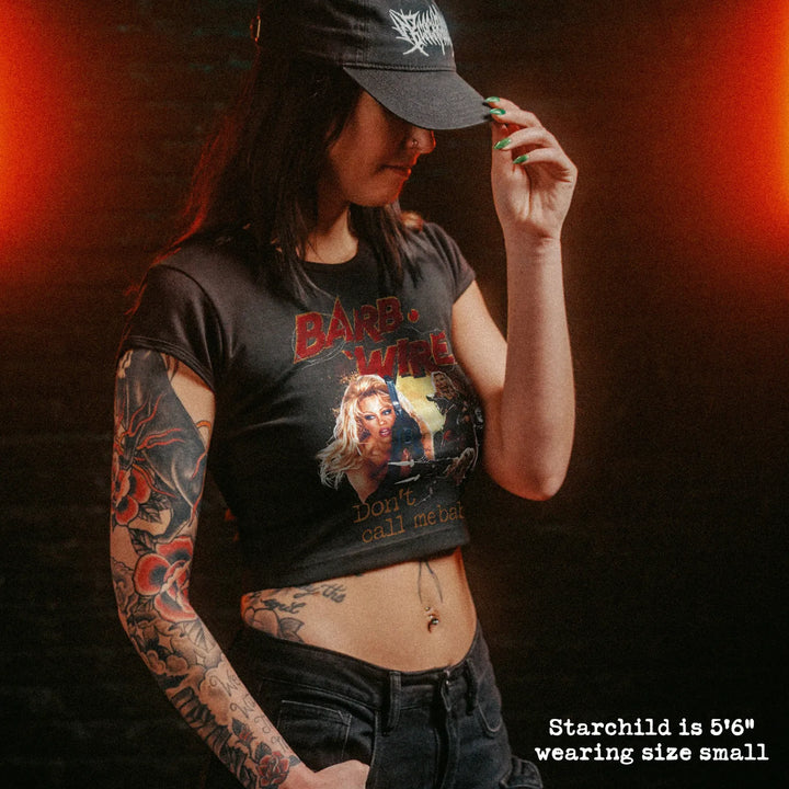 Female model wearing cropped baby tee with barb wire graphic
