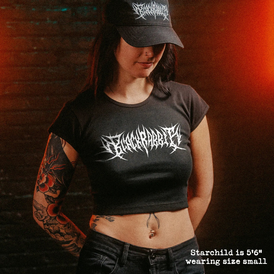 Female model wearing cropped baby tee with black rabbit death metal graphic

