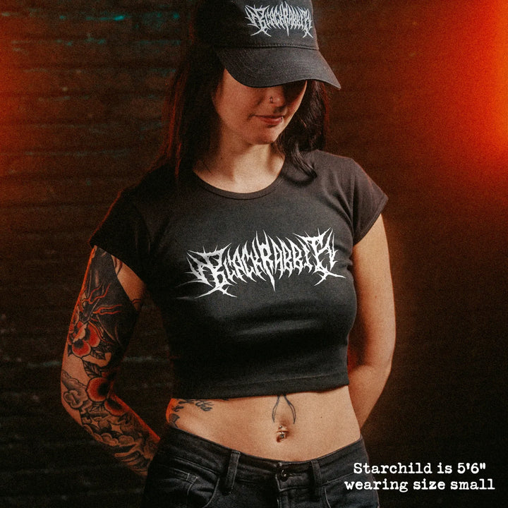 Female model wearing cropped baby tee with black rabbit death metal graphic
