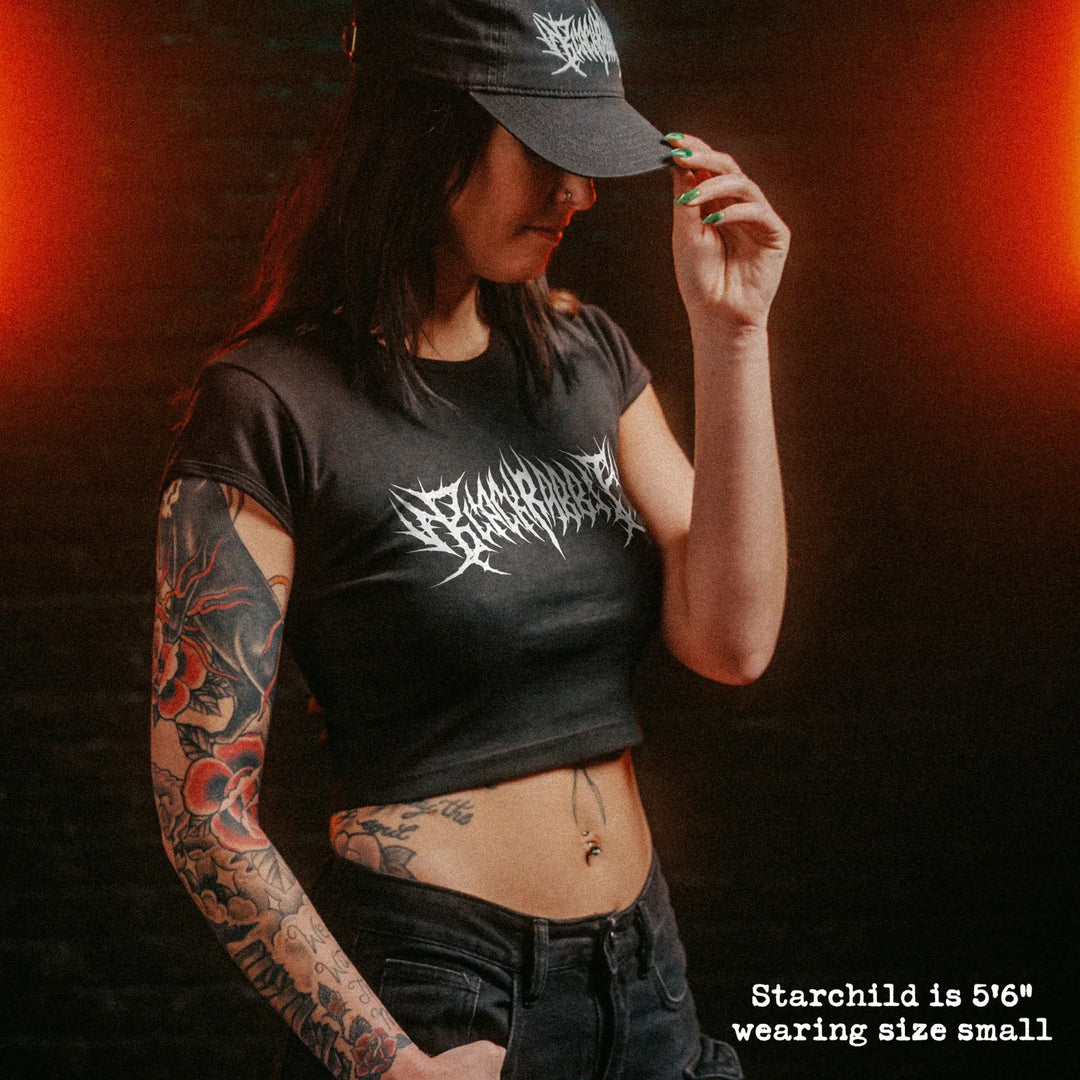 Female model wearing cropped baby tee with black rabbit death metal graphic
