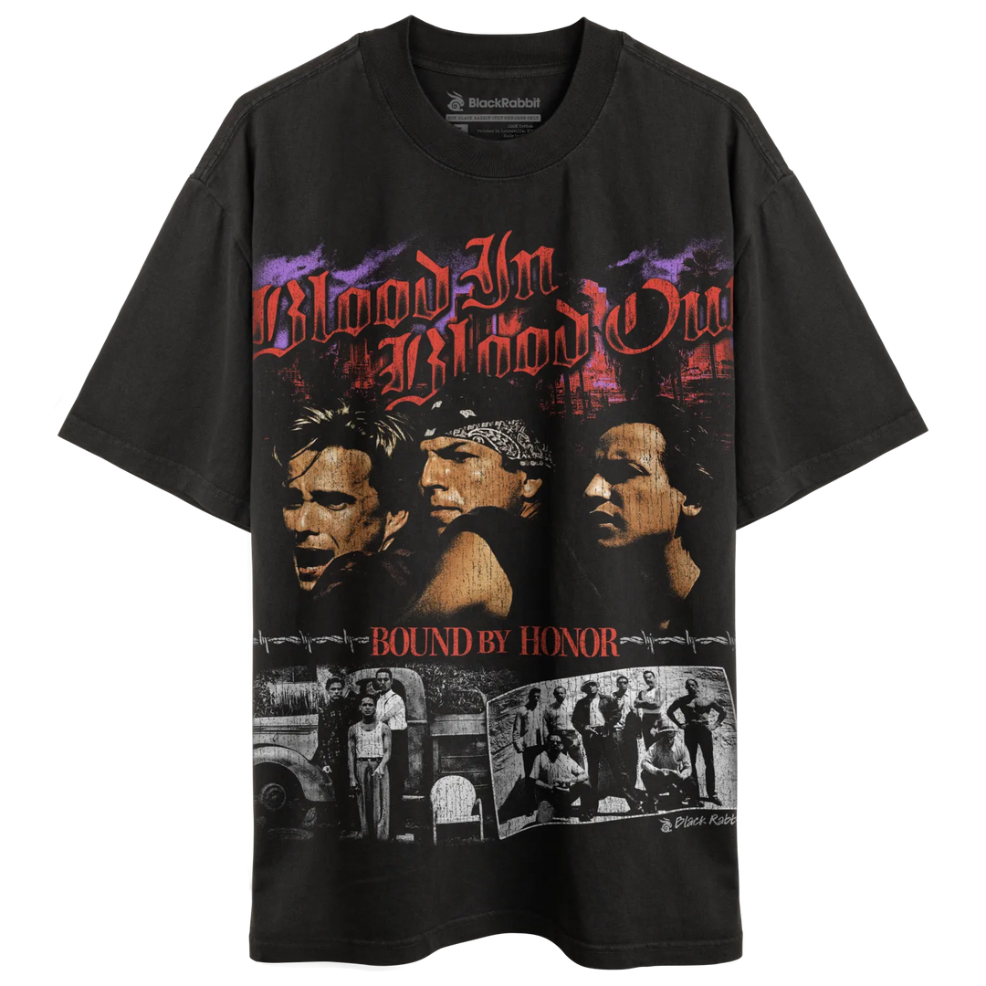A black t-shirt with a graphic print featuring three men’s faces and the text ’Blood In Blood Out’ and ’Bound By Honor,’ along with smaller black and white images below.