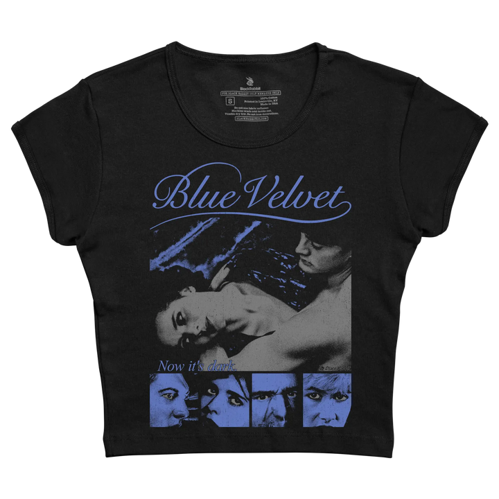 Black short-sleeved t-shirt featuring a blue-toned graphic of the ’blue velvet’ movie poster with the title in cursive script and the phrase “now it’s dark” below.