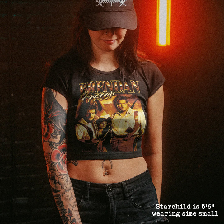 Female model wearing cropped baby tee with brendan fraser graphic
