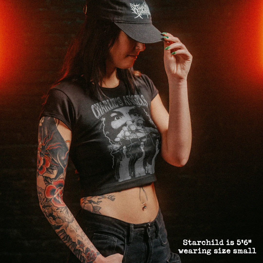 Female model wearing cropped baby tee with manson family graphic
