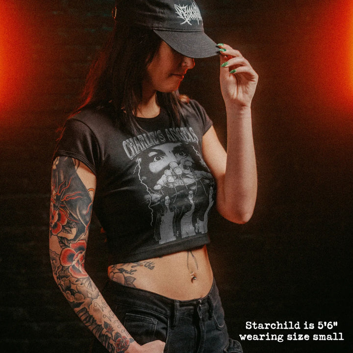 Female model wearing cropped baby tee with manson family graphic
