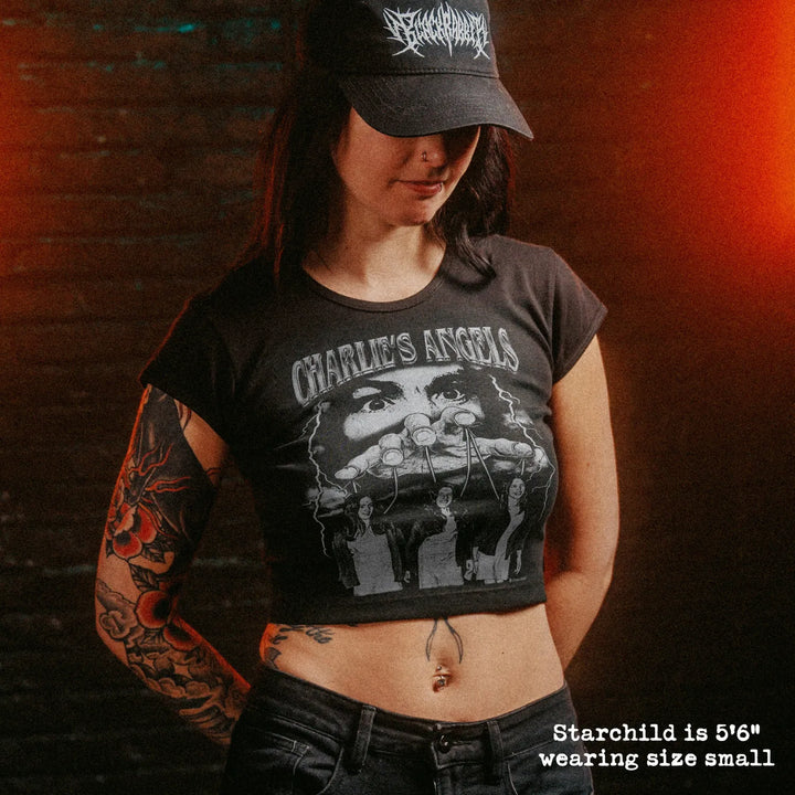 Female model wearing cropped baby tee with manson family graphic
