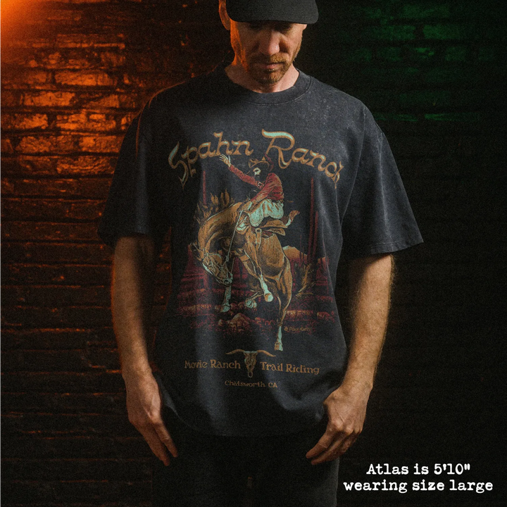 Male model wearing heavy stone washed tee with spahn ranch graphic. 