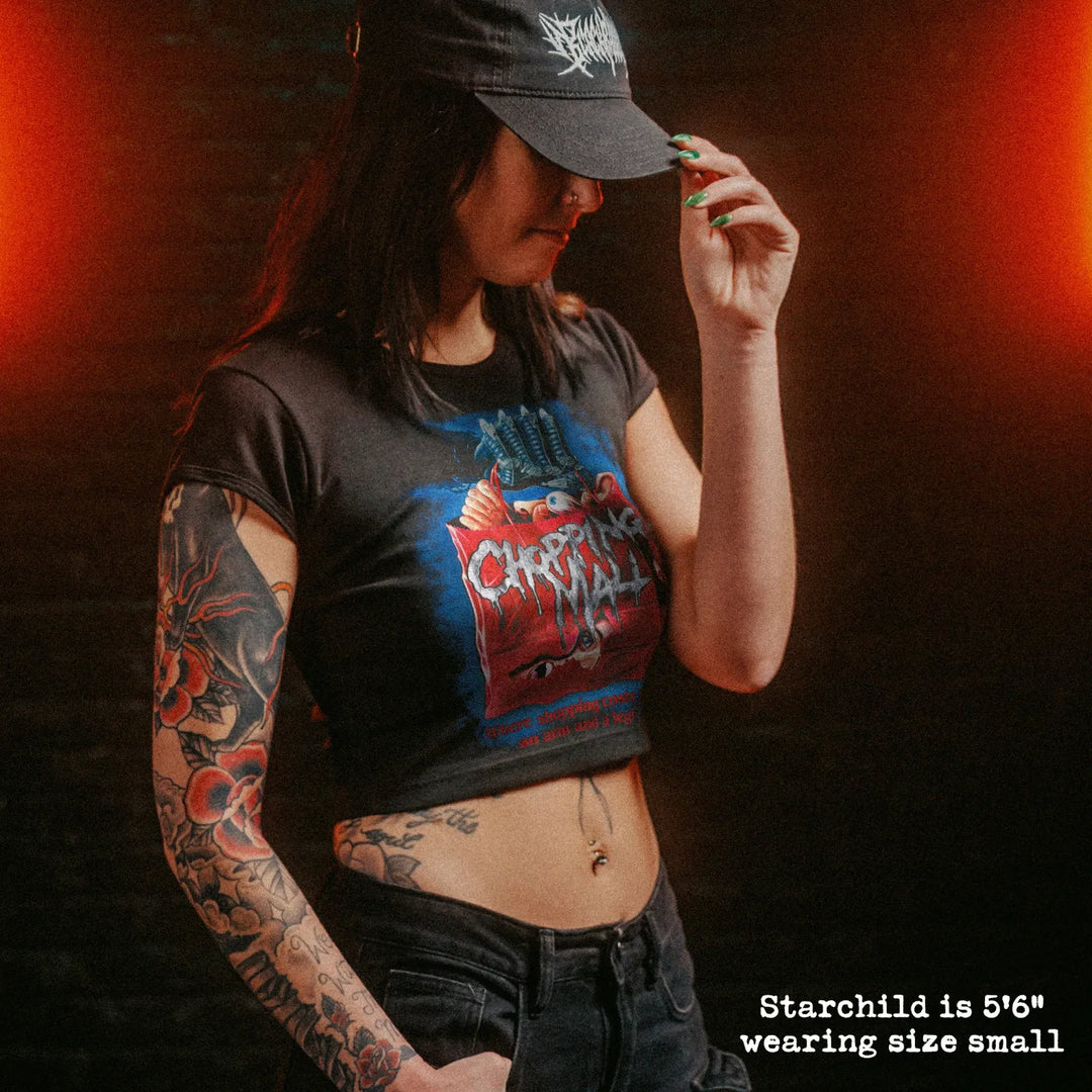 Female model wearing cropped baby tee with chopping mall graphic
