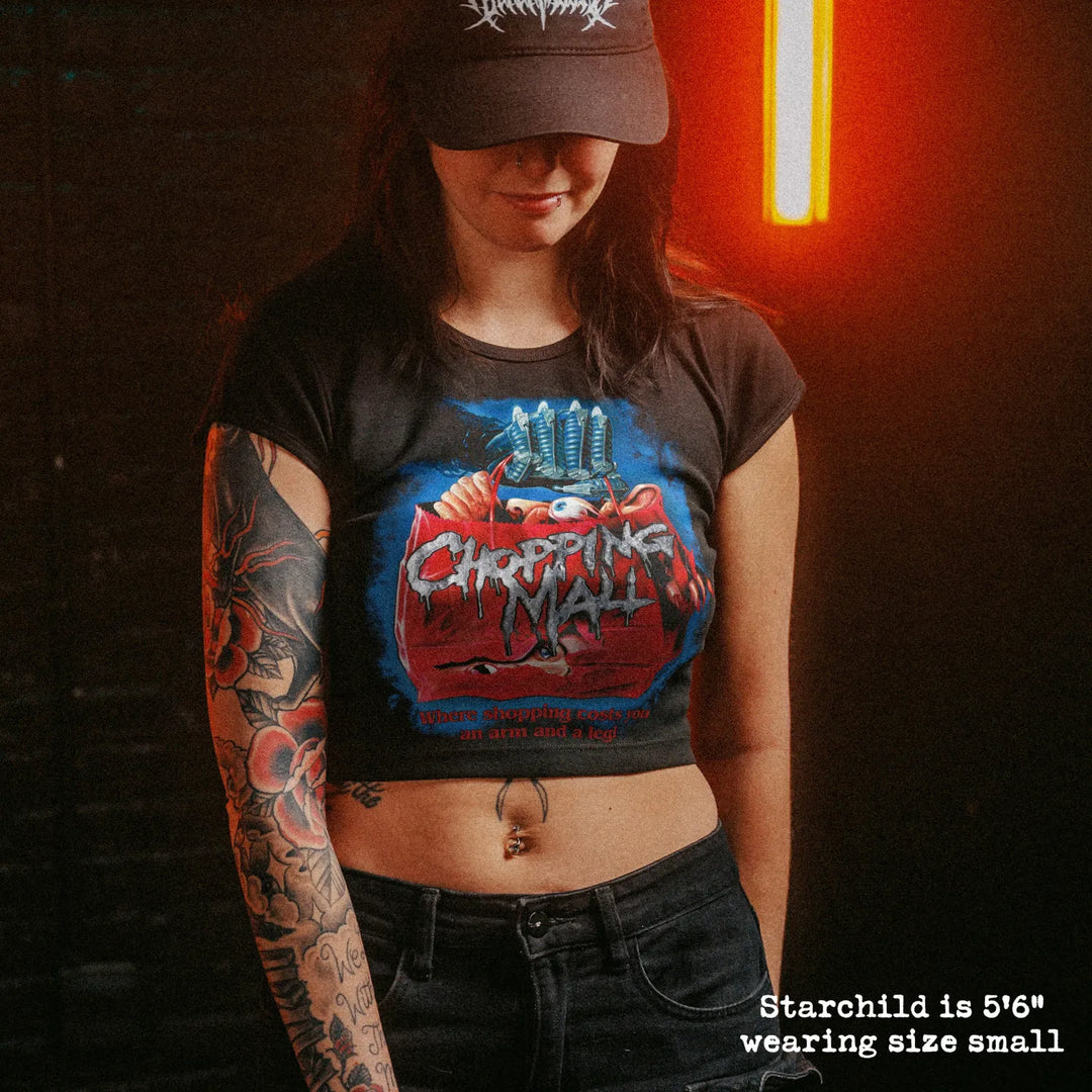Female model wearing cropped baby tee with chopping mall graphic
