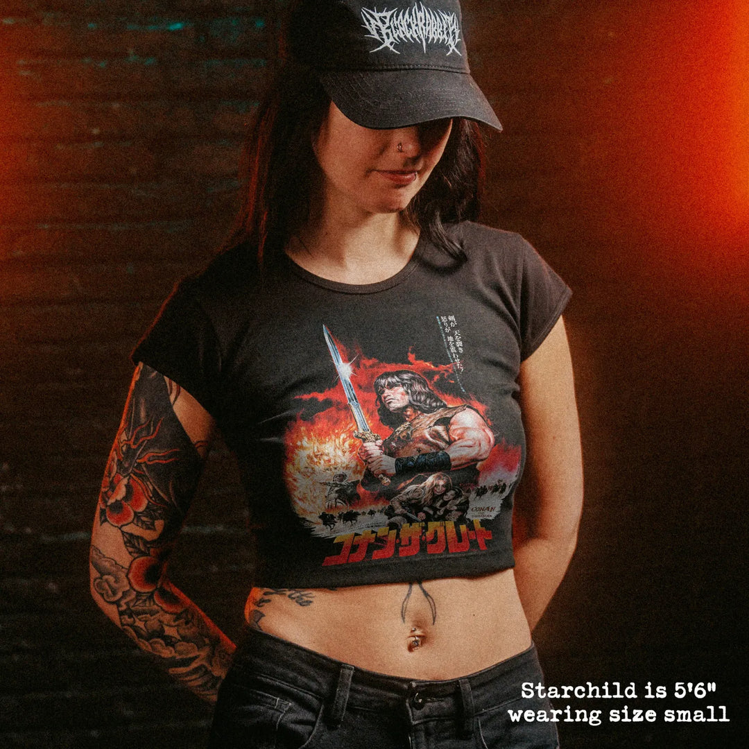 Female model wearing cropped baby tee with conan japan graphic
