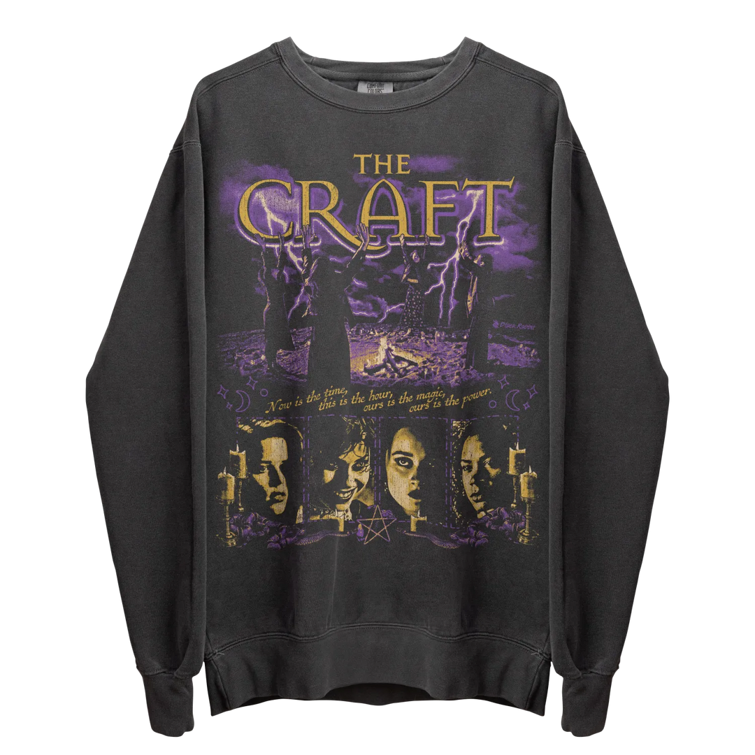Dark grey long-sleeved crewneck sweatshirt with a purple and gold graphic print.