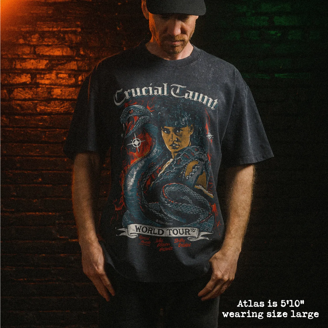 Male model wearing stone wash heavy tee with crucial taunt graphic 