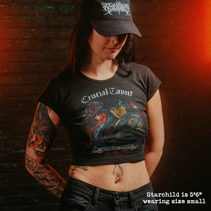 Female model wearing cropped baby tee with crucial taunt graphic
