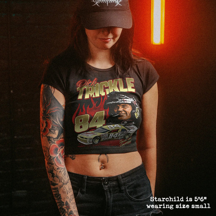 Female model wearing cropped baby tee with dick trickle graphic
