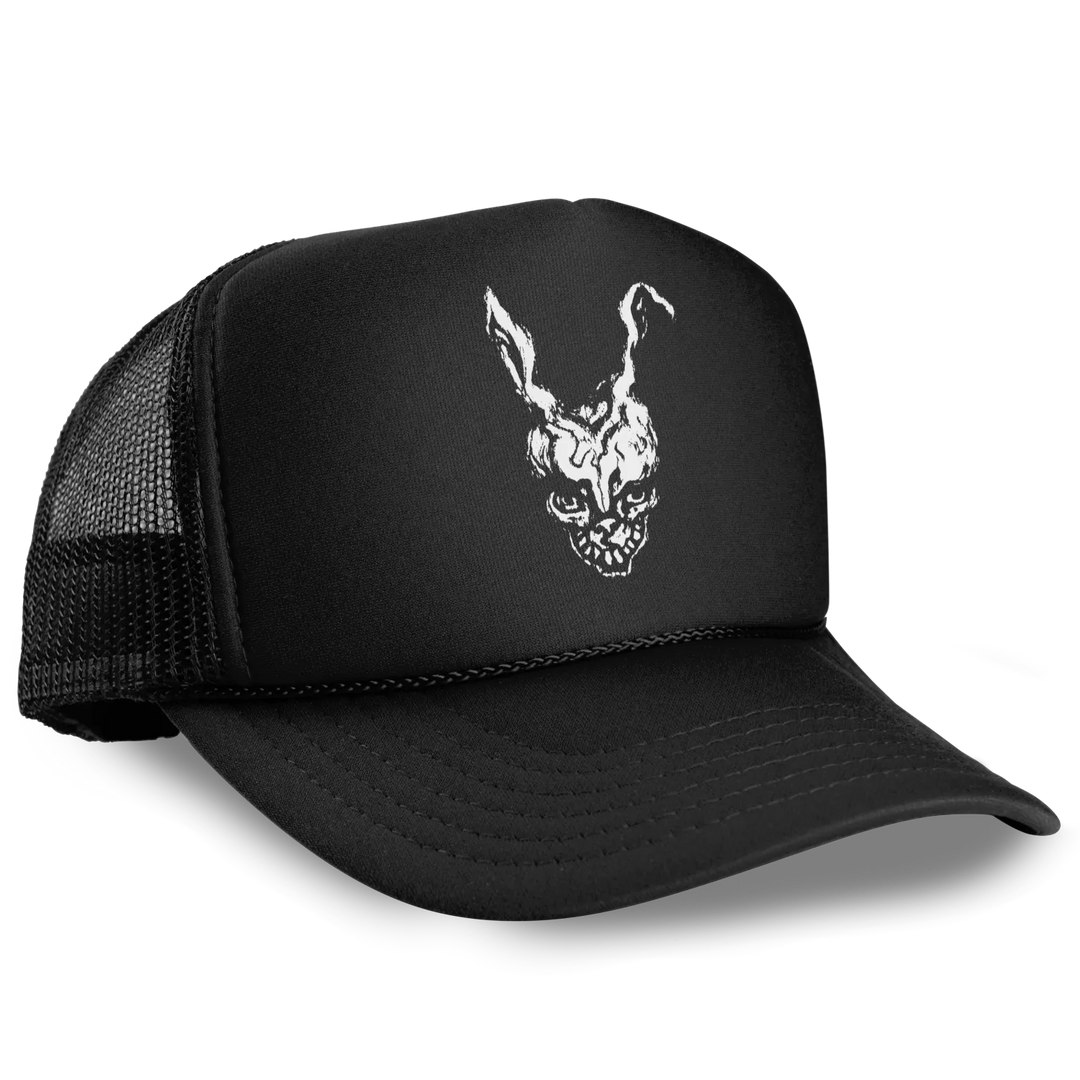 A classic foam-front black trucker hat with a white graphic of Frank from Donnie Darko 