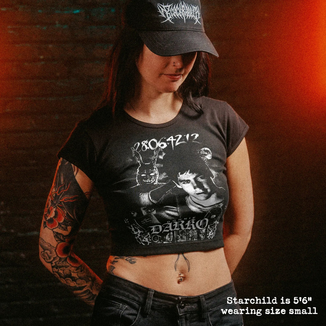 Female model wearing cropped baby tee with Donnie Darko graphic
