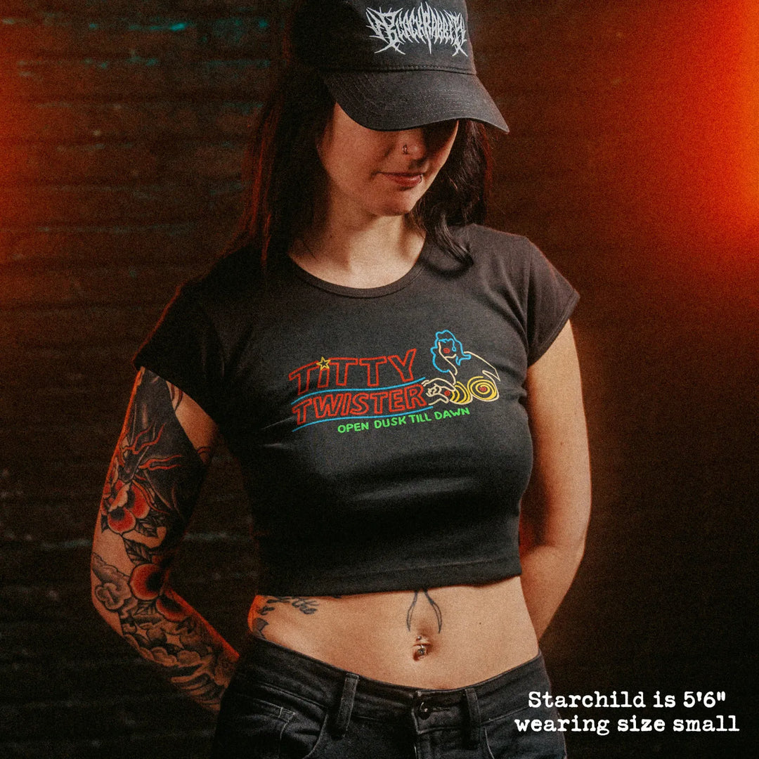 Female model wearing cropped baby tee with titty twister graphic

