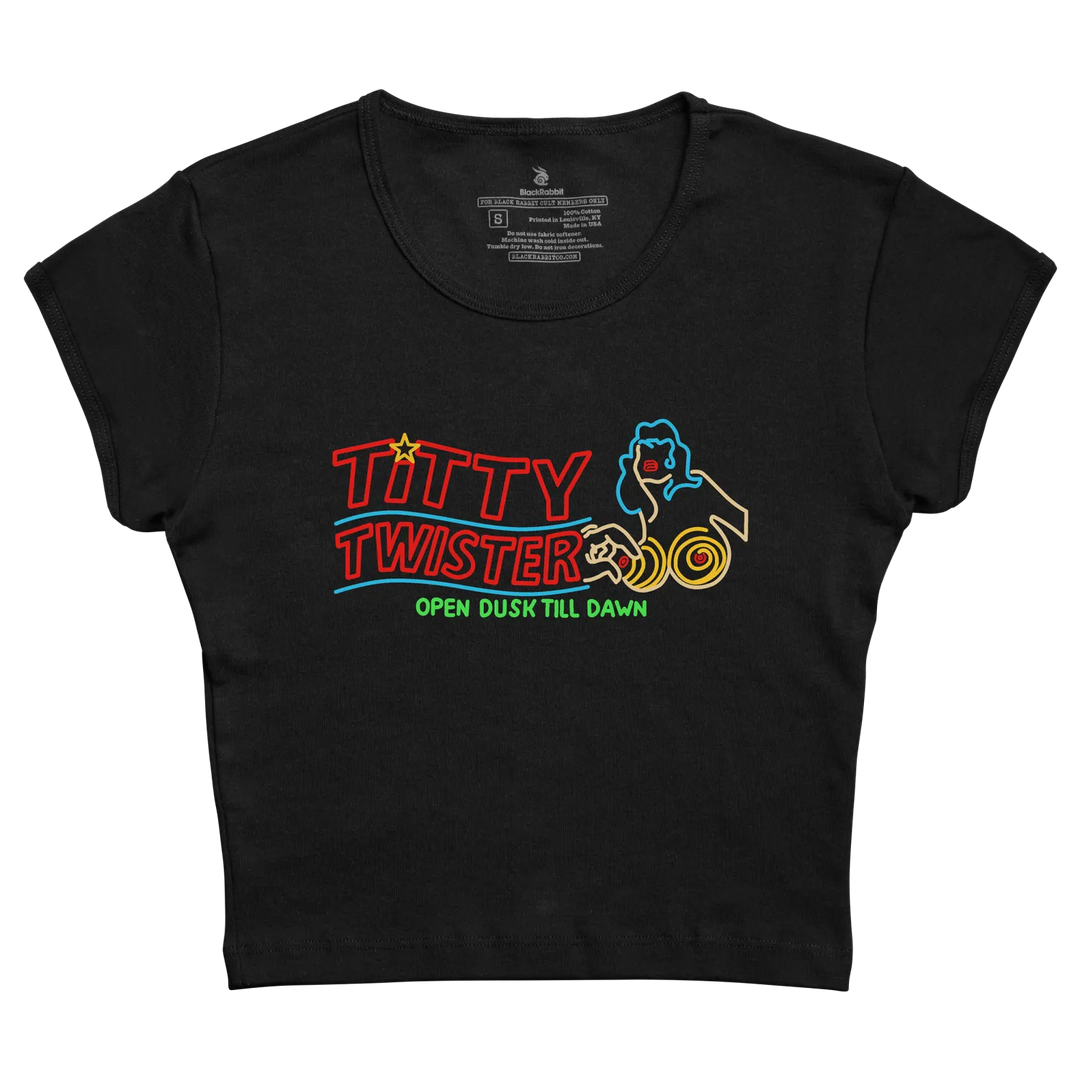 Black cropped t-shirt featuring a neon-style graphic of the titty twister logo with red, blue, and yellow lettering and design elements. 