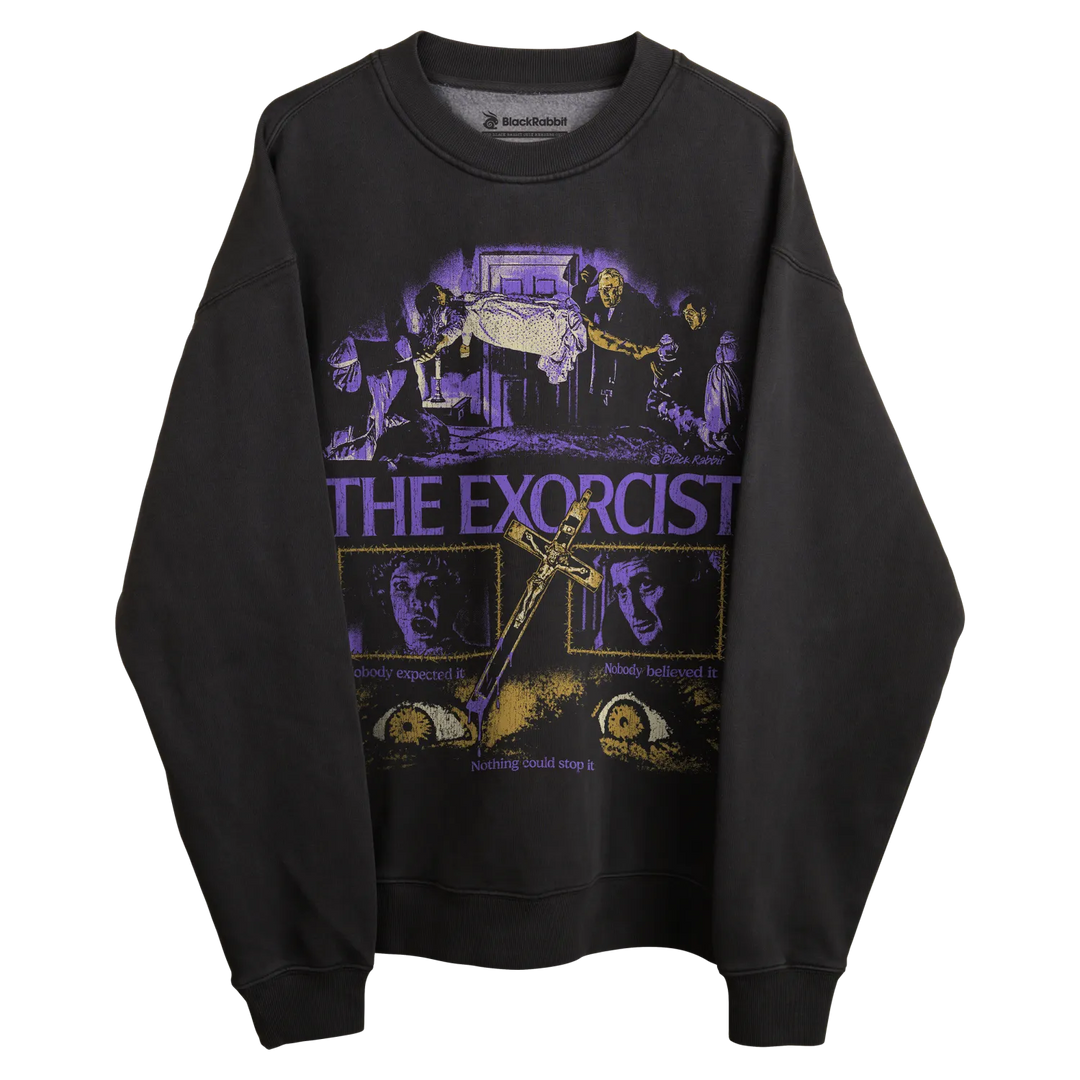 Black long-sleeved sweatshirt with ’the exorcist’ graphic design featuring purple text and illustrations.