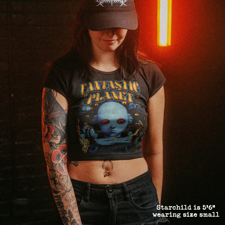 Female model wearing cropped baby tee with fantastic planet english graphic
