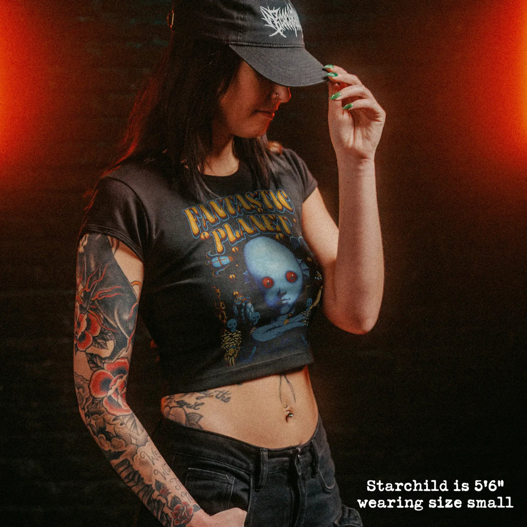 Female model wearing cropped baby tee with fantastic planet english graphic
