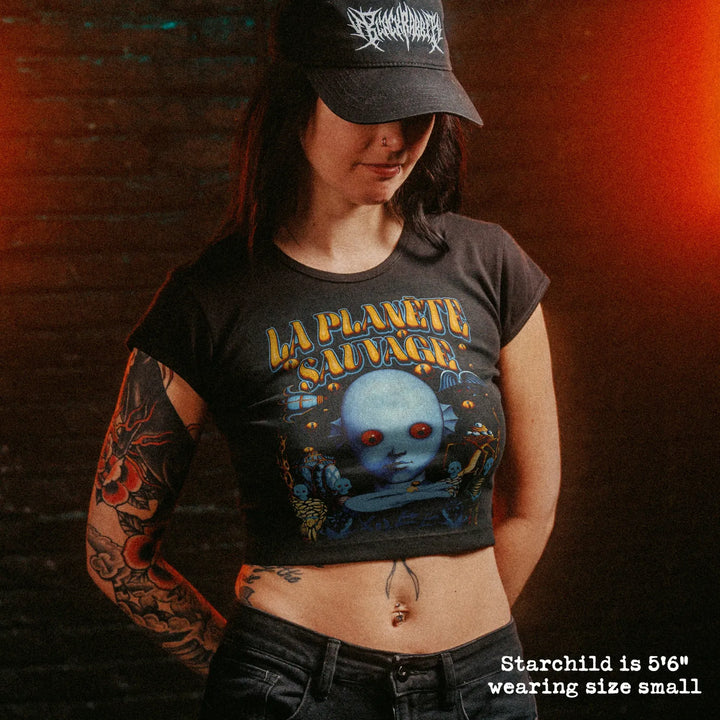Female model wearing cropped baby tee with fantastic planet french graphic
