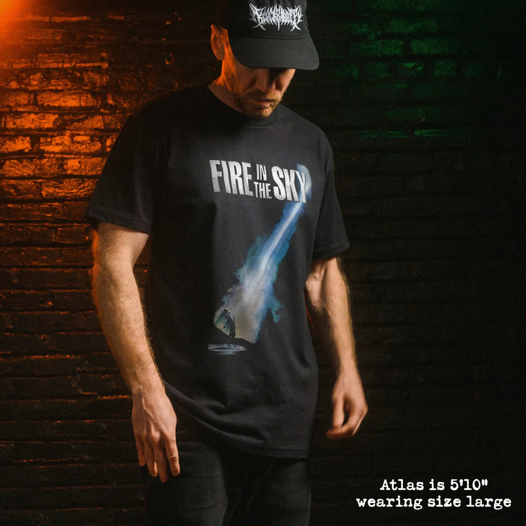 Male model wearing black premium tee with fire in the sky graphic 