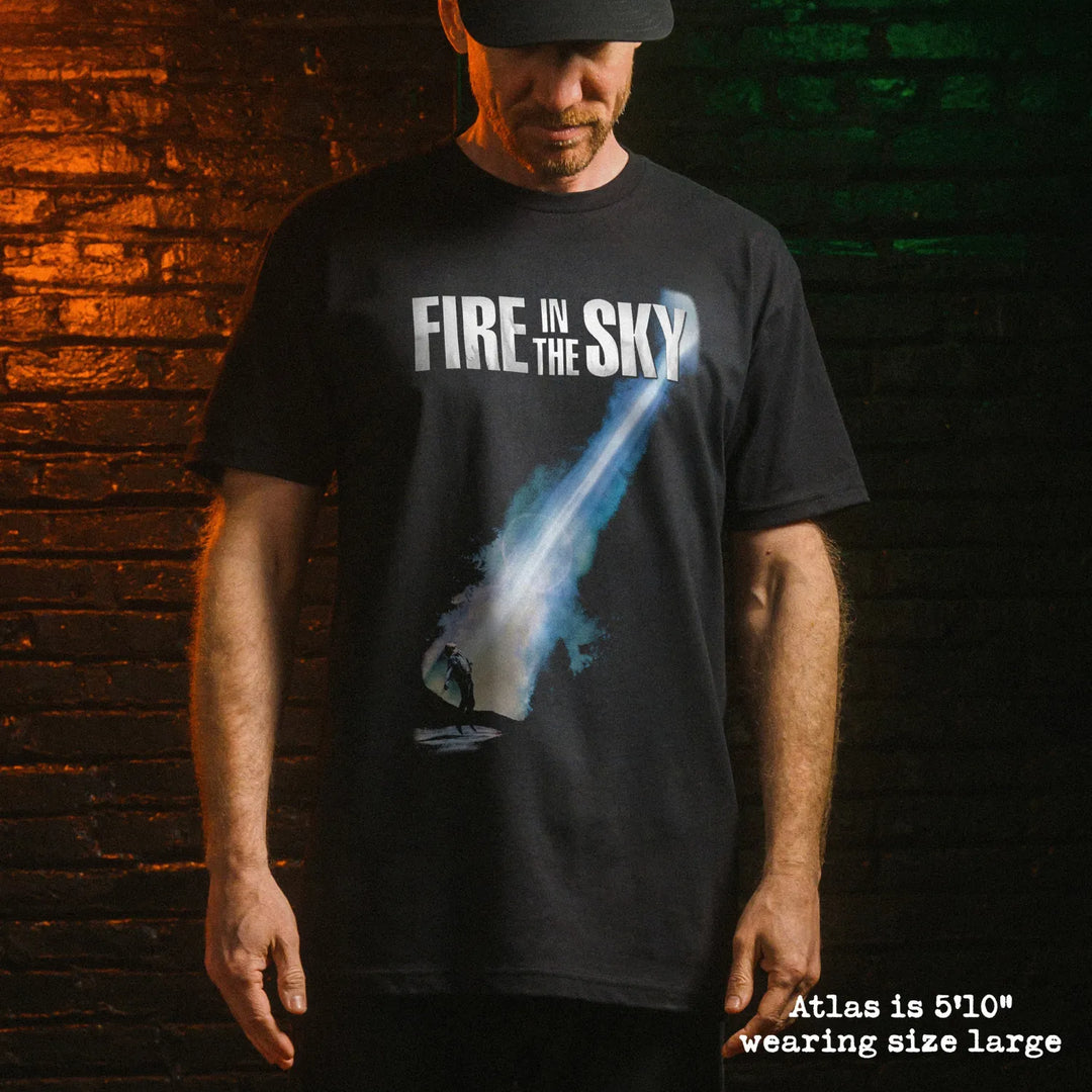 Male model wearing black premium tee with fire in the sky graphic 