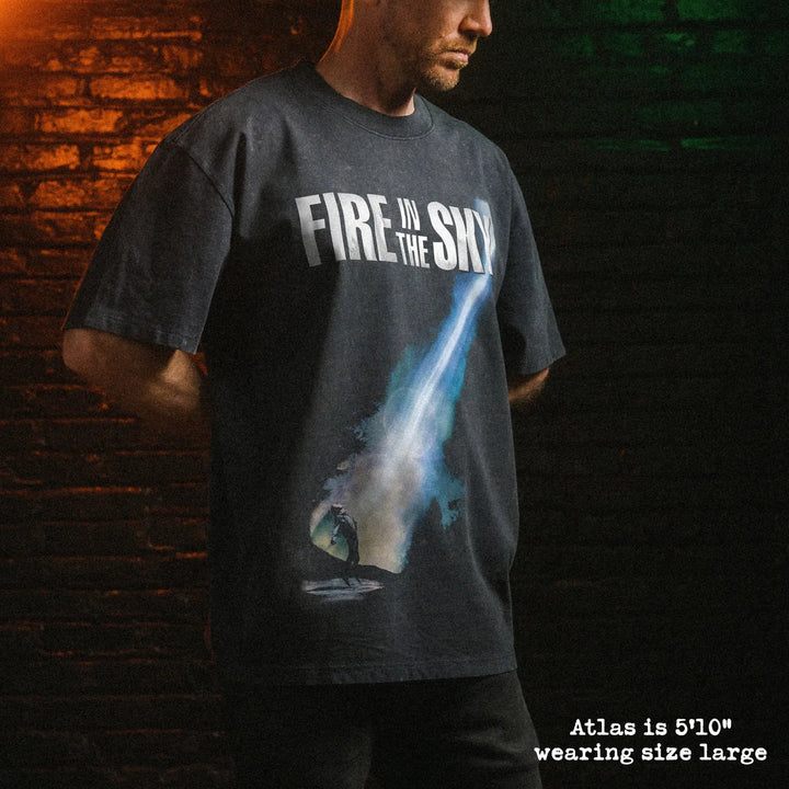 Male model wearing stone wash heavy tee with fire in the sky graphic 