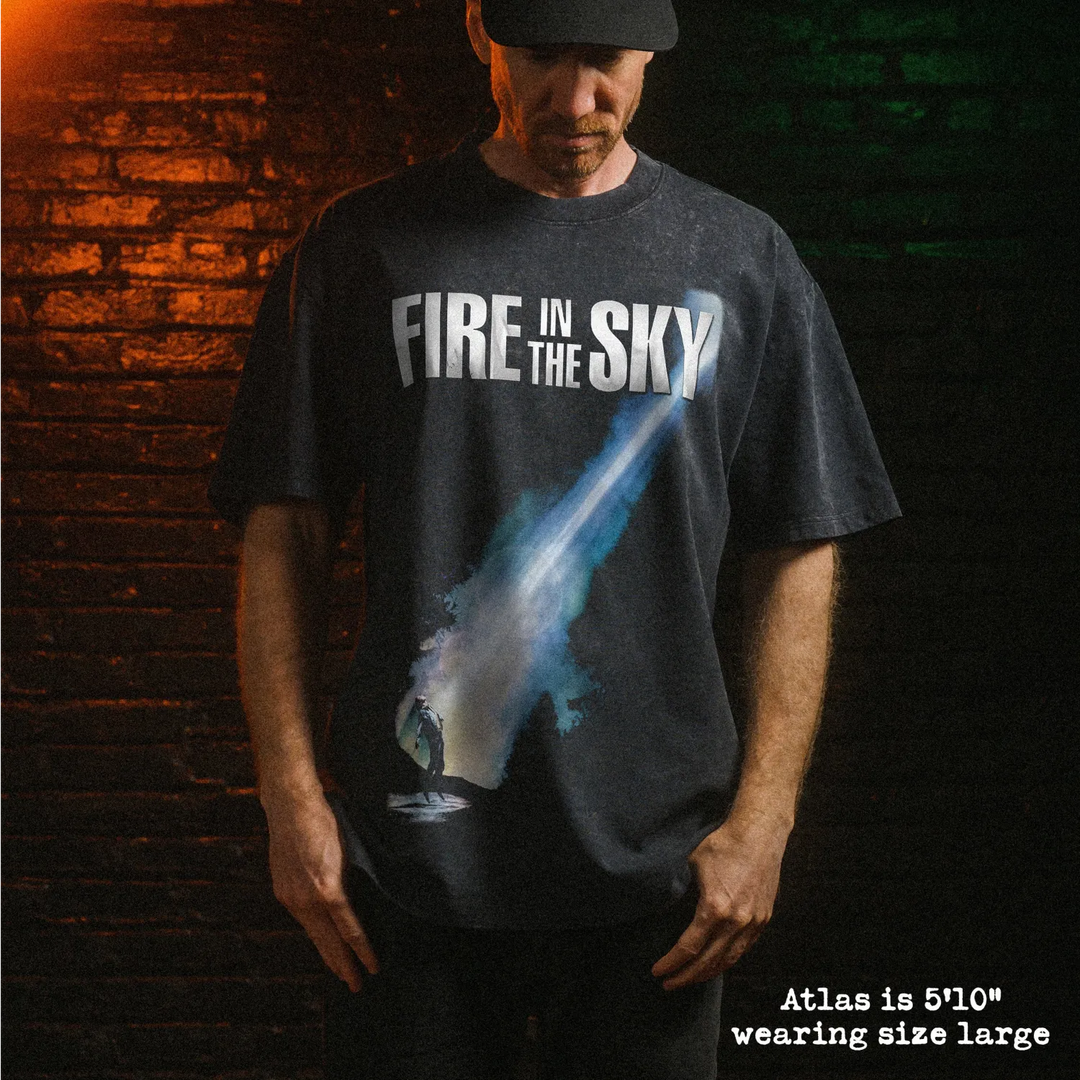 Male model wearing stone wash heavy tee with fire in the sky graphic 