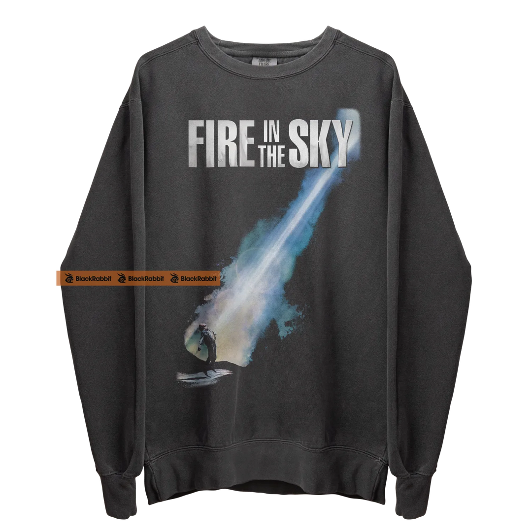 Gray sweatshirt with ’Fire in the Sky’ graphic.