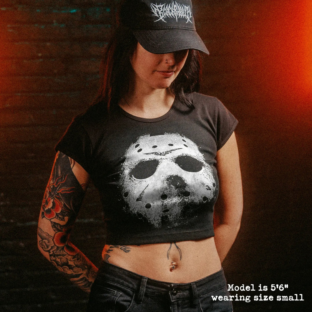 Female model wearing cropped baby tee with jason mask graphic
