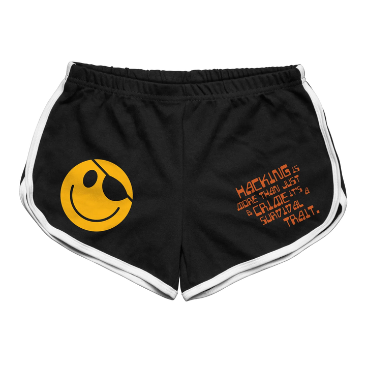 Black athletic shorts with white trim and a yellow smiley face graphic featuring an eyepatch on the left leg, along with orange text reading ’hacking is more than just a craze.