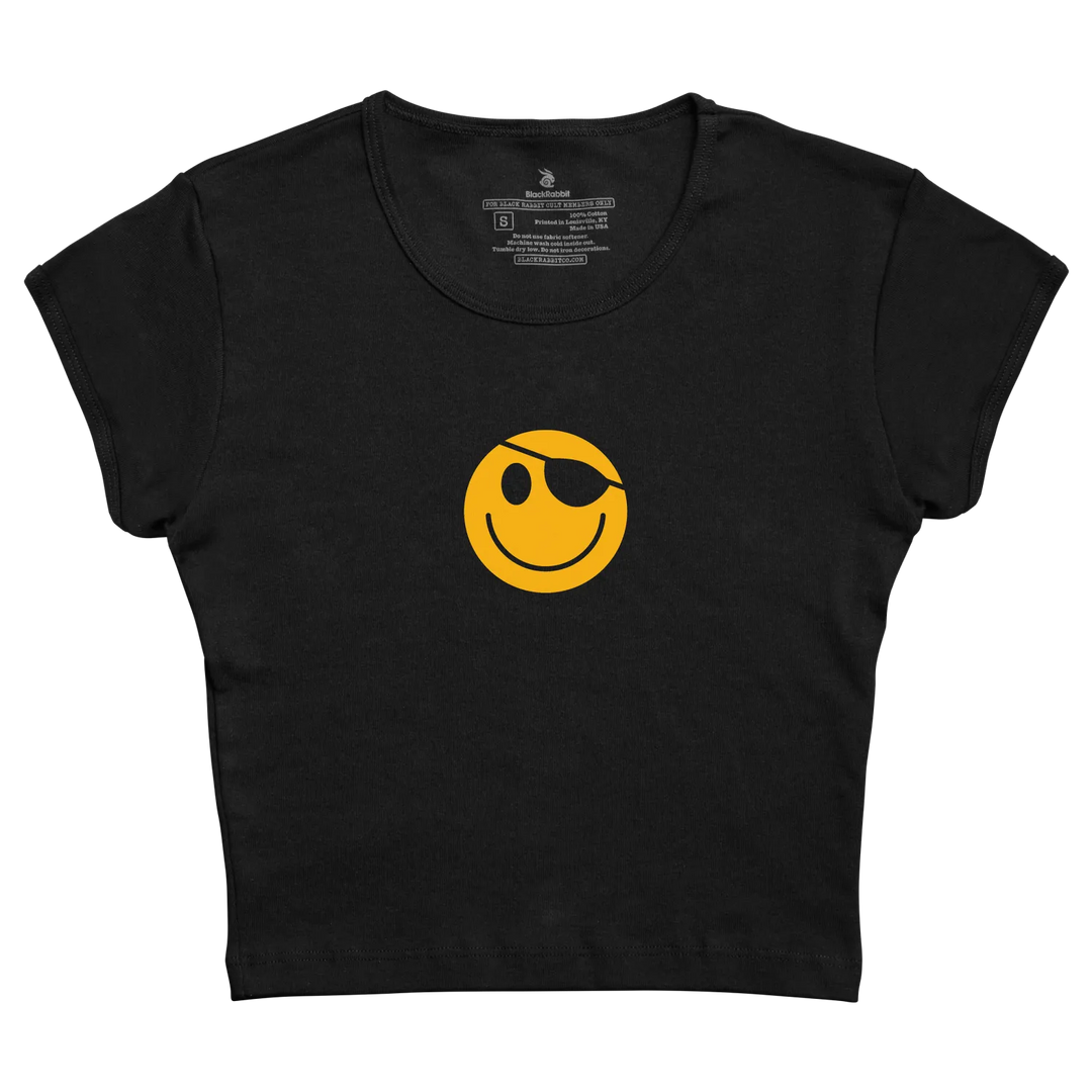 Black cropped tee featuring a bold yellow smiley face with an eye patch.