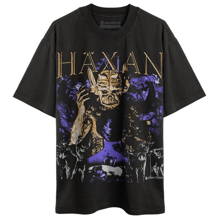 A black t-shirt with a graphic print featuring a demonic figure and the word ’HAXAN’ in gold lettering.