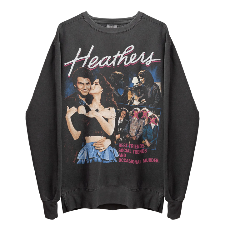 Black long-sleeved crewneck sweatshirt with a colorful graphic print featuring characters from the movie ’Heathers’ and the text ’BEST FRIENDS, SOCIAL TRENDS AND OCCASIONAL MURDER.’