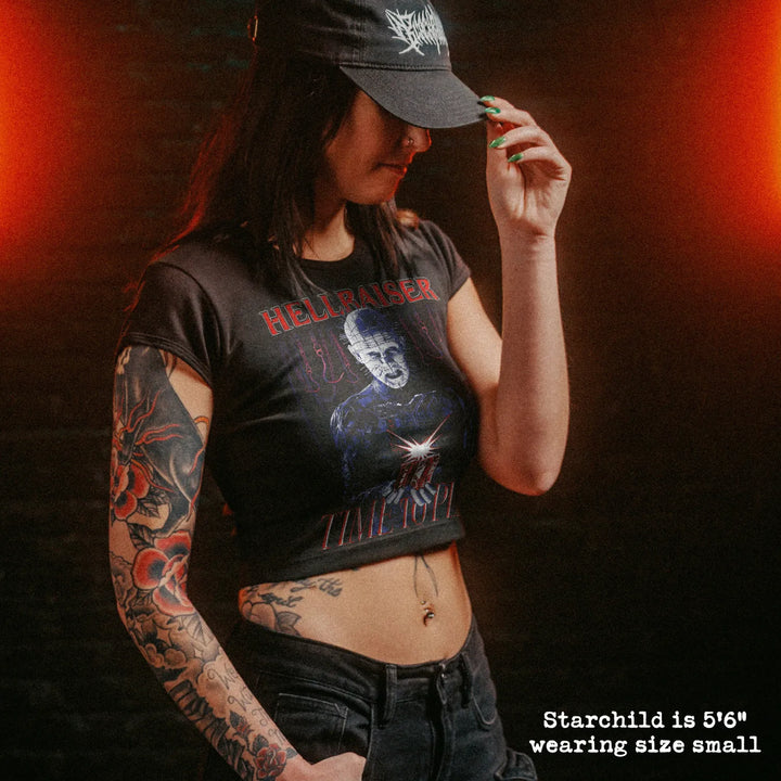 Female model wearing cropped baby tee with hellraiser graphic
