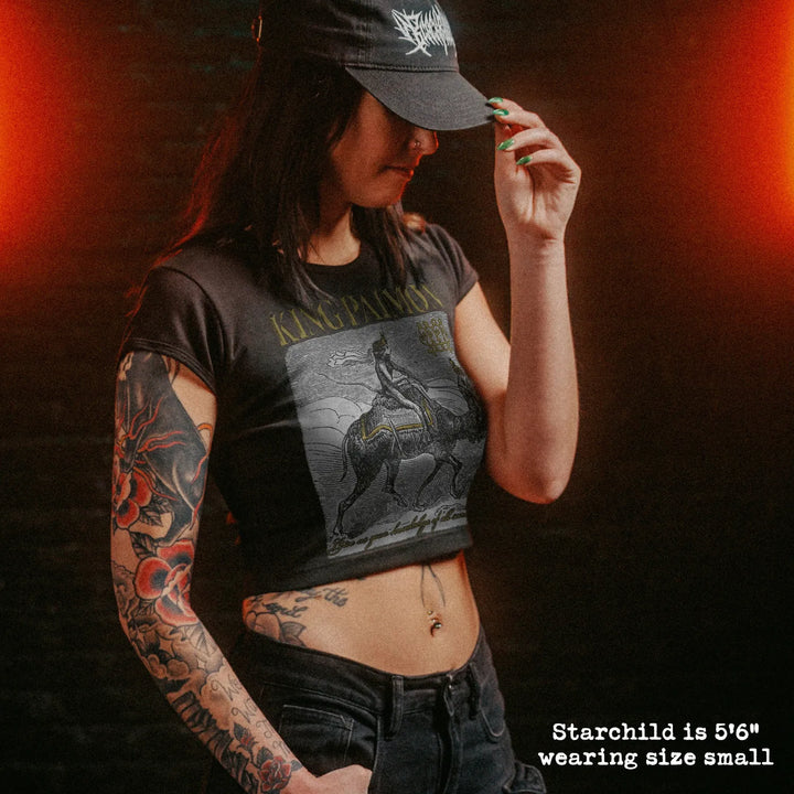 Female model wearing cropped baby tee with king paimon graphic
