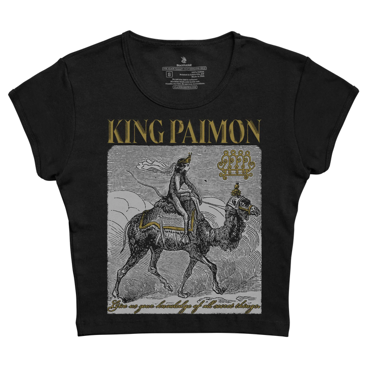 Black short-sleeved t-shirt featuring a detailed black-and-white illustration of king paimon riding a camel, accented with gold lettering and decorative elements.