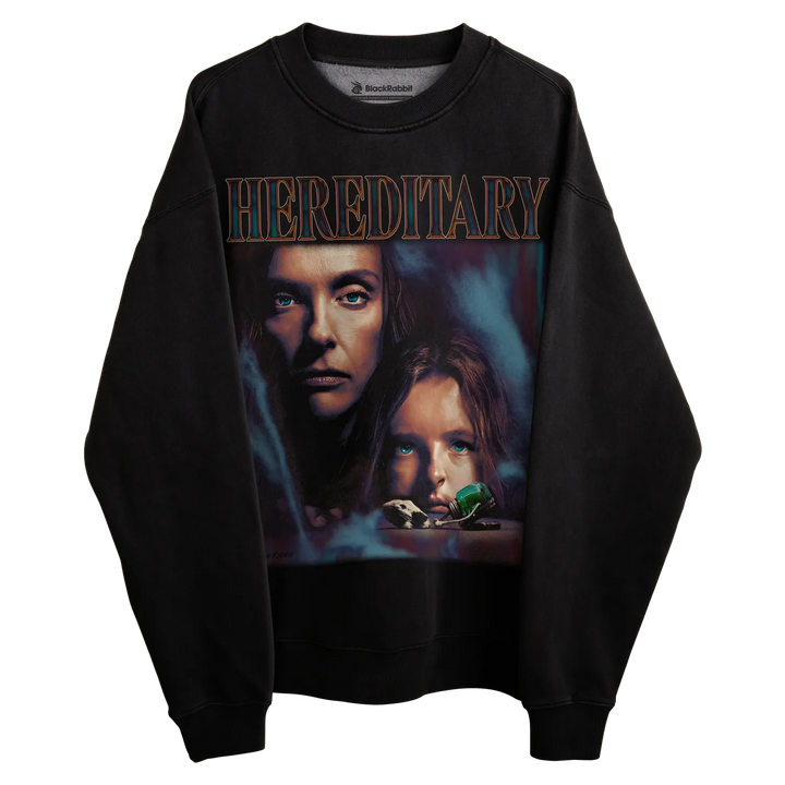 Black crewneck sweatshirt with ’hereditary’ graphic design featuring two faces and a green object.