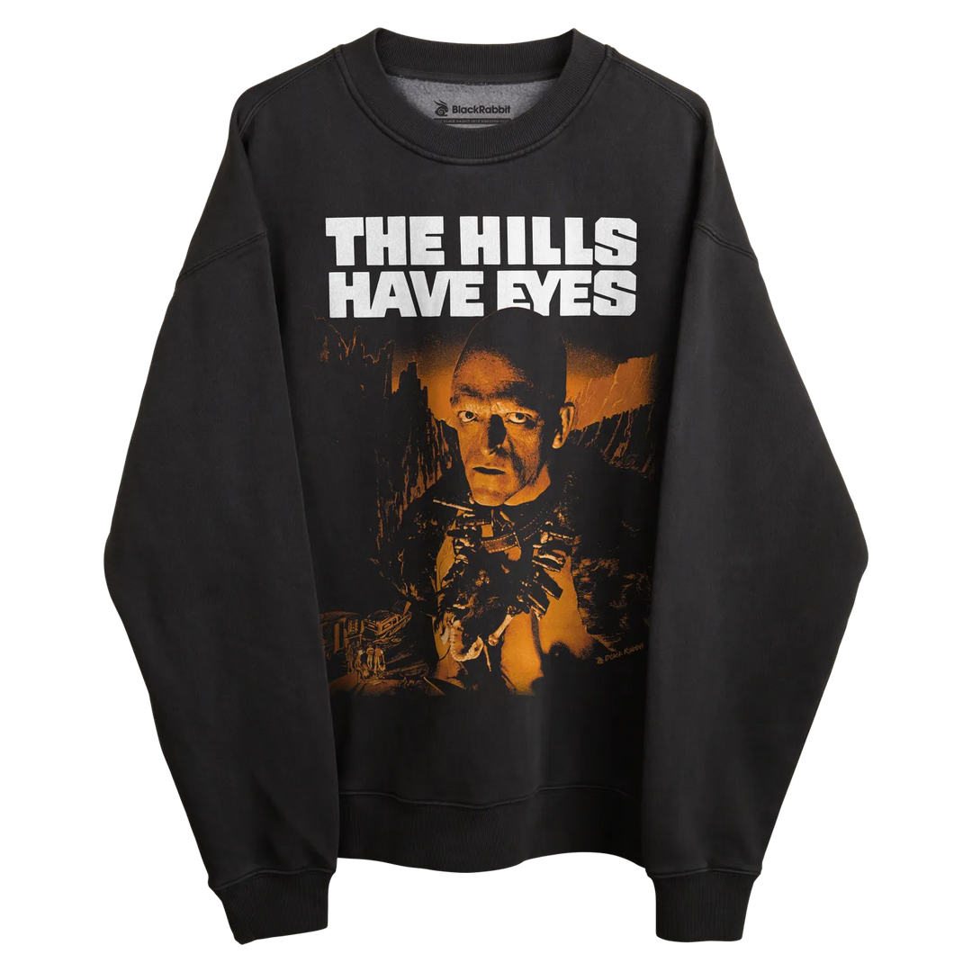 Black crewneck sweatshirt with ’the hills have eyes’ graphic and text design.