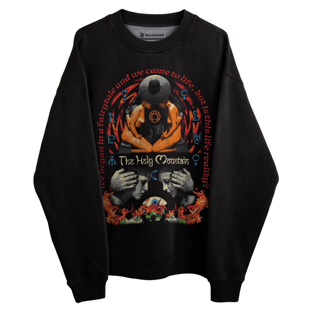 Black long-sleeved sweatshirt with graphic design featuring two faces and a central eye, floral patterns at the bottom hem.